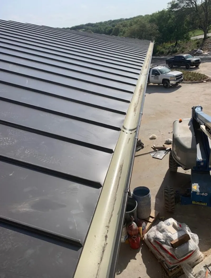Standing seam panel and gutter detail on a metal roofing jobsite in Clarksdale